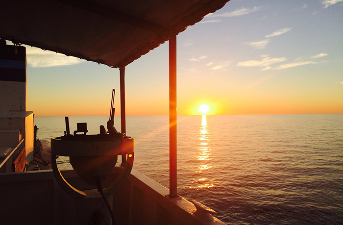 A sunrise as seen from a vessel in water.