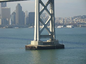 In the foreground, the Bay Bridge tower that was hit by the M/V Cosco Busan, spilling oil into San Francisco Bay and the Pacific Ocean.