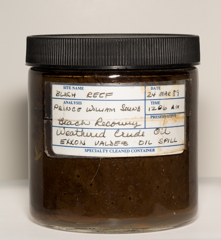 A jar of oil from the Exxon Valdez oil spill labeled with general information about the spill.