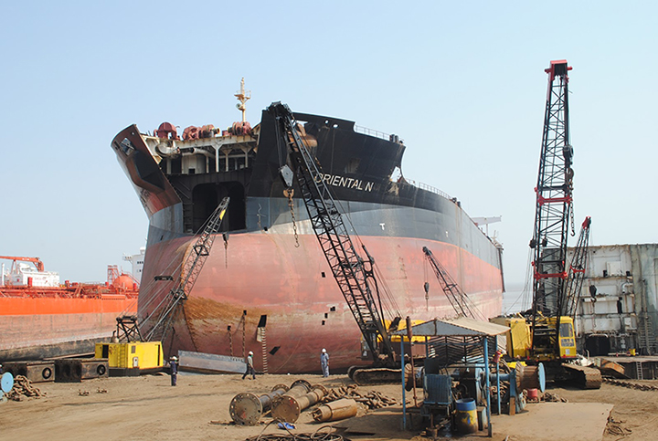 Ship being dismantled on a beach in India.