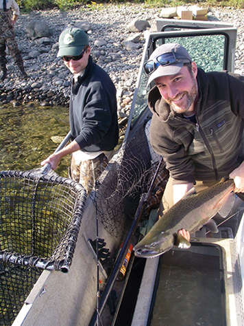 A NOAA scientist takes stock of a male Chinook salmon during their fall run along the Hanford Reach in 2013.