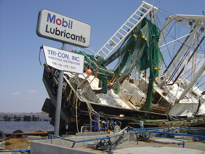 A damaged boat setting on a  fuel dock.