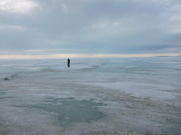 Man in the distance walking on sea ice.