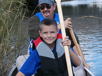 A man and his grandson canoeing on Woodbridge River.
