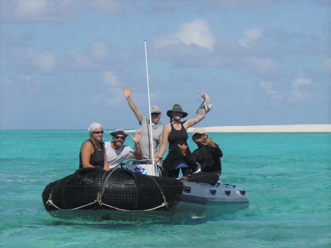 A group of people on a small boat in water.