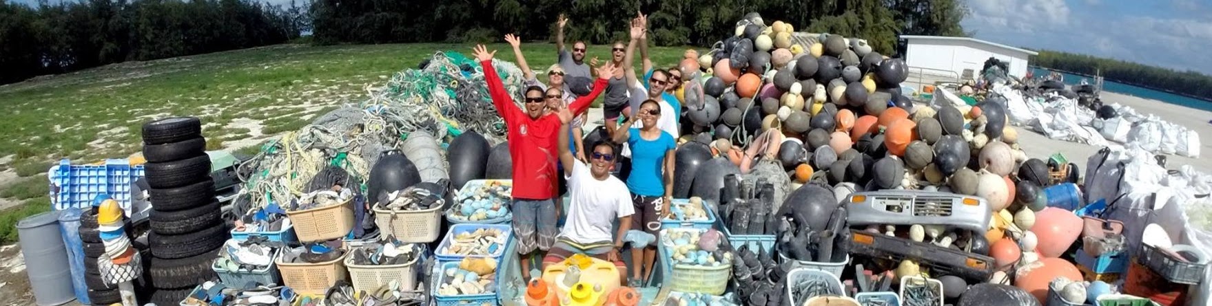 A group of people surrounded by a large pile of trash. 