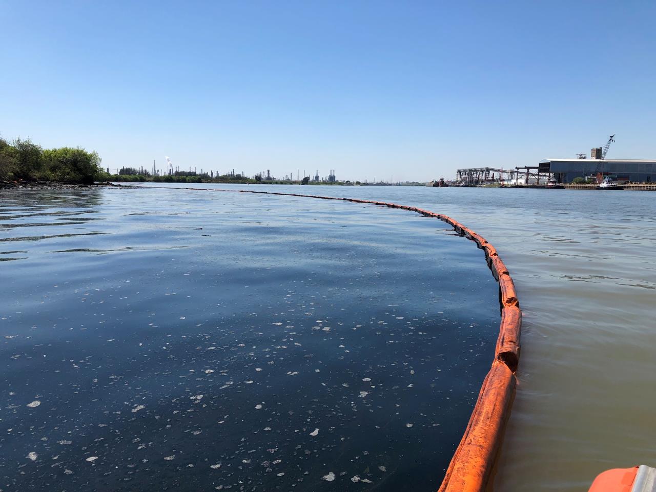 A pollution boom with oil in the water on one side.