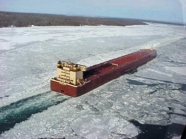 A vessel moving through ice on a river.