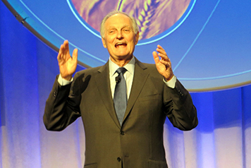 A man gesturing on a stage.