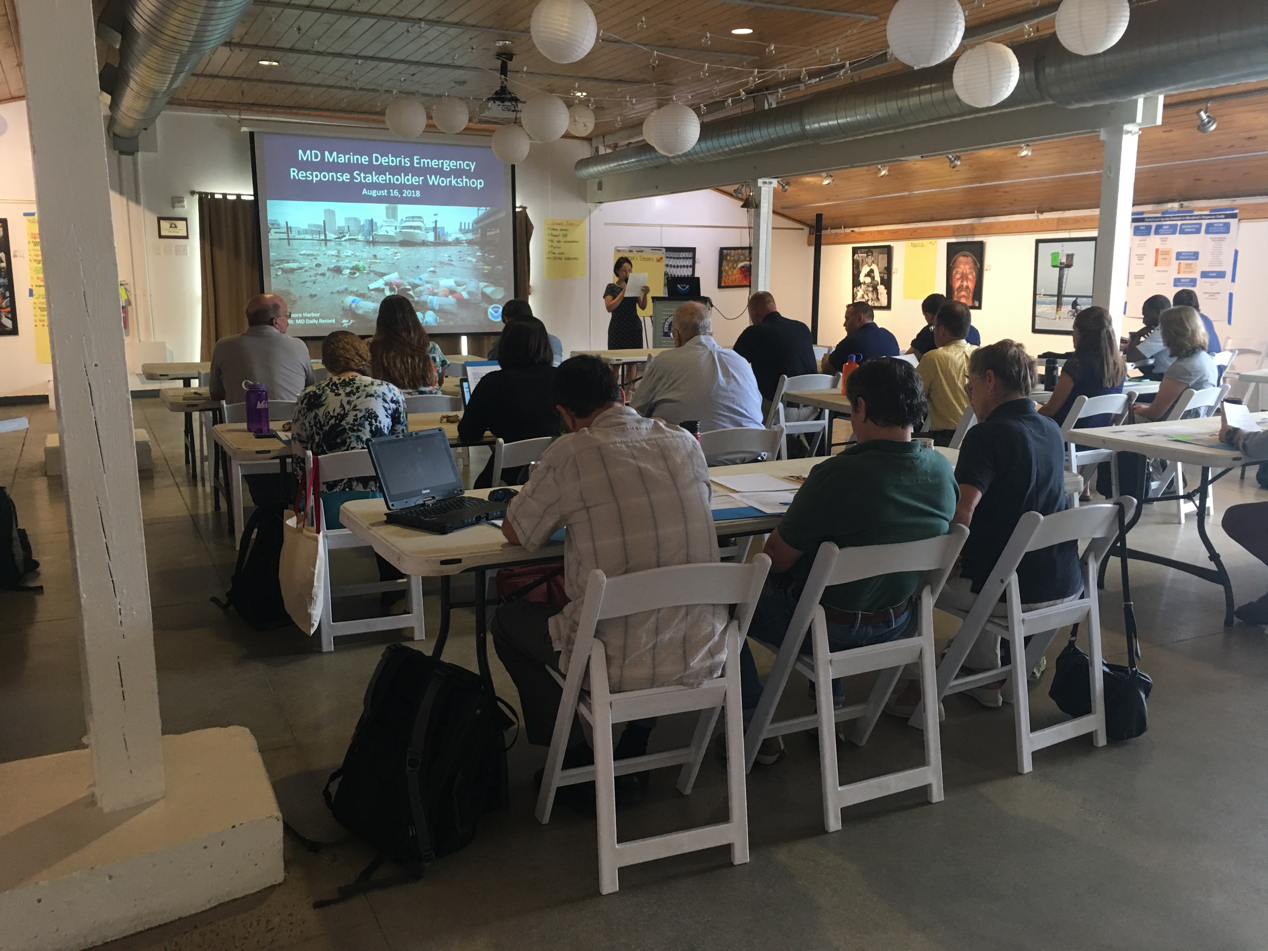 A group of people in a conference area watching a presentation. 