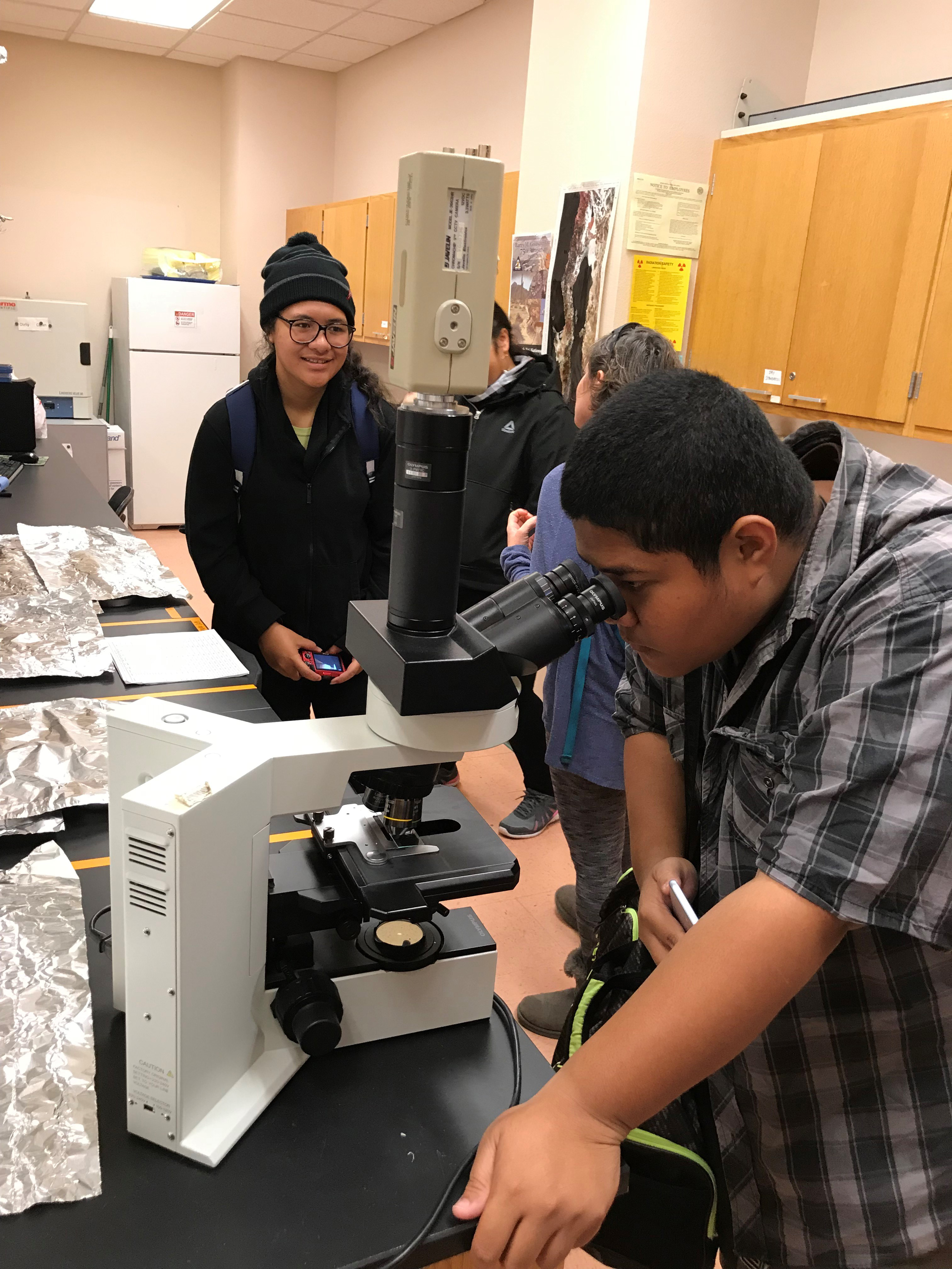 Student looking into a microscope.