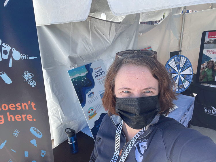 A person in a mask standing under a tent.