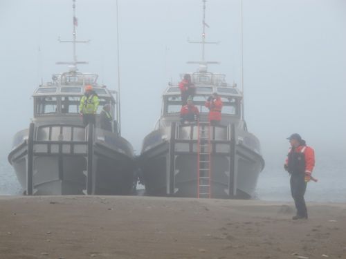Two boats in fog with man on beach. Image: NOAA.