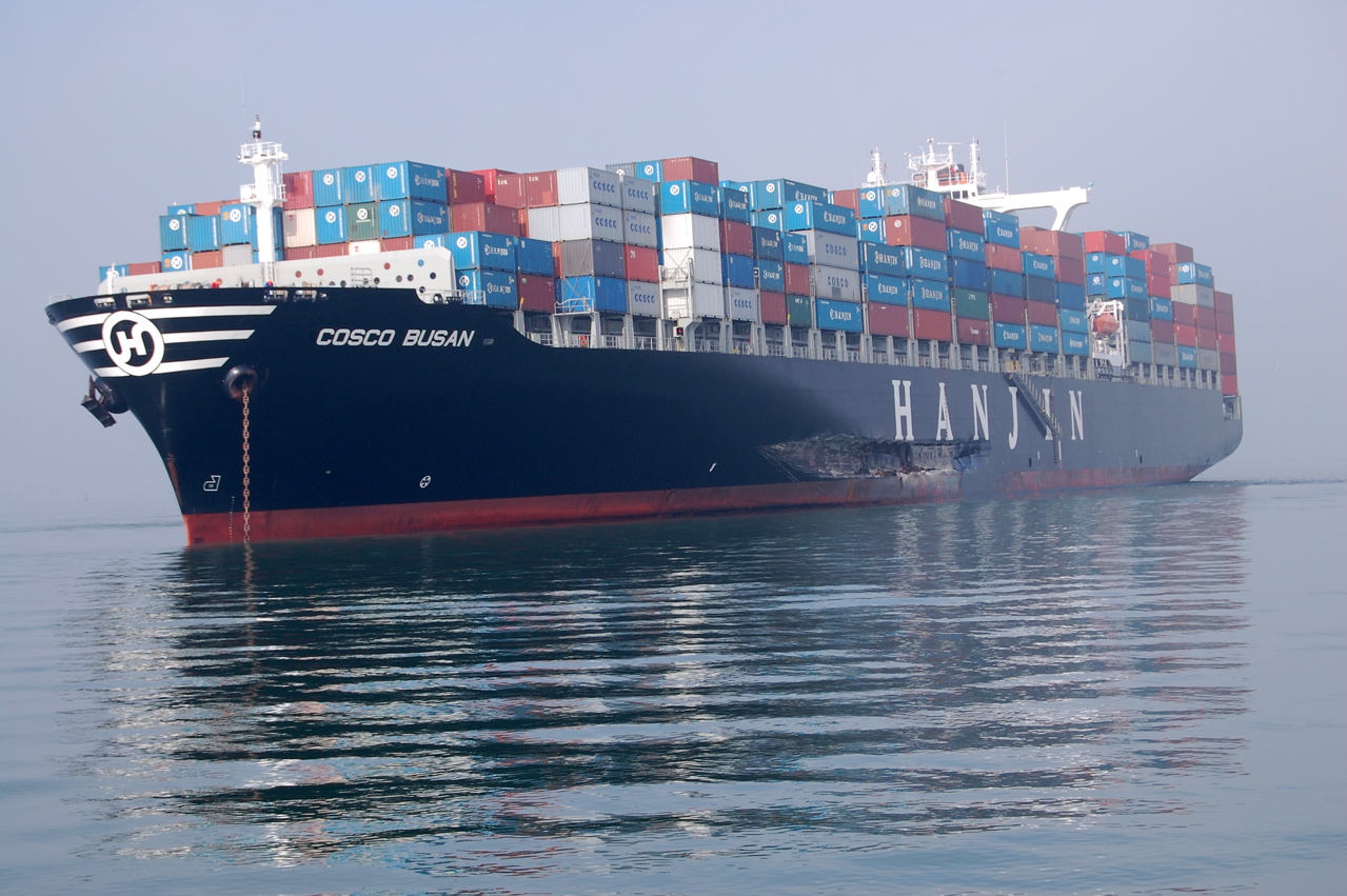 A large shipping vessel loaded with containers. A gash appears on the port side over the text "Hanjin."