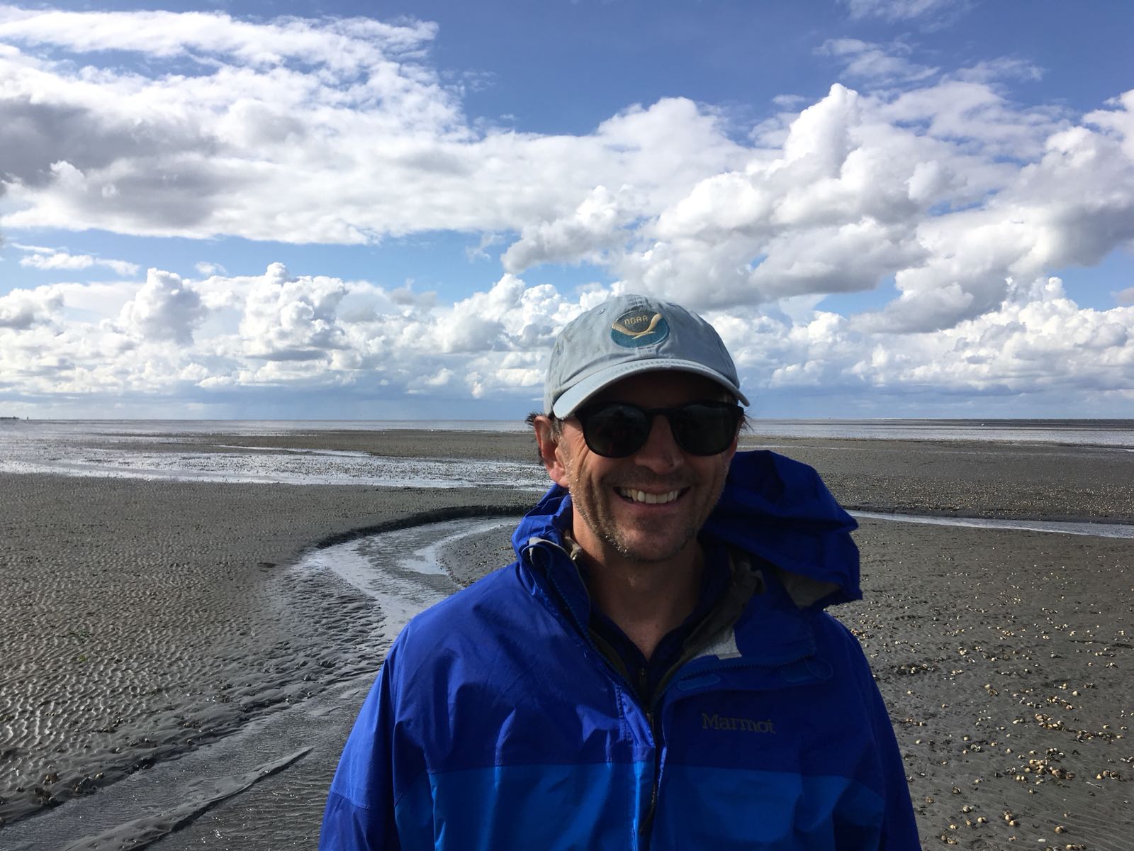 Man posing for photo on a beach.