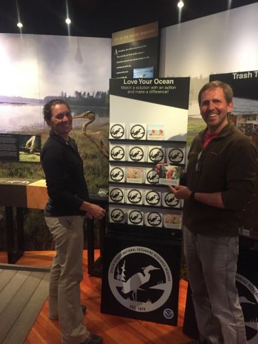 Two men standing with a panel display.