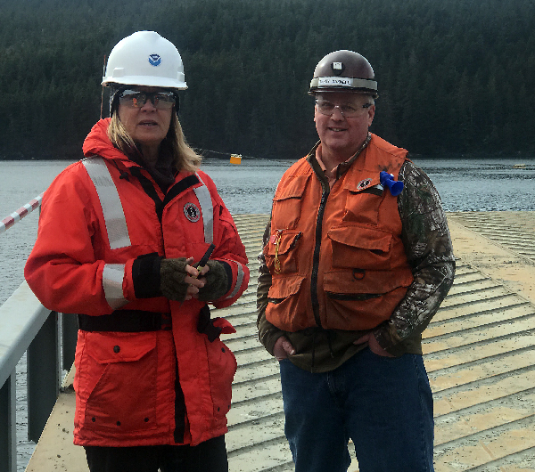 A man and a woman standing on a dock.