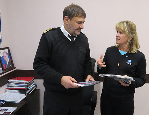 Man and woman discussing next to a desk.