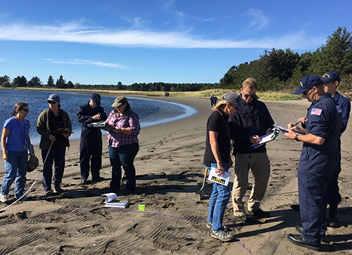 Two groups of people talking on a beach.