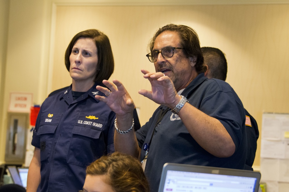 Woman standing next to speaking man.