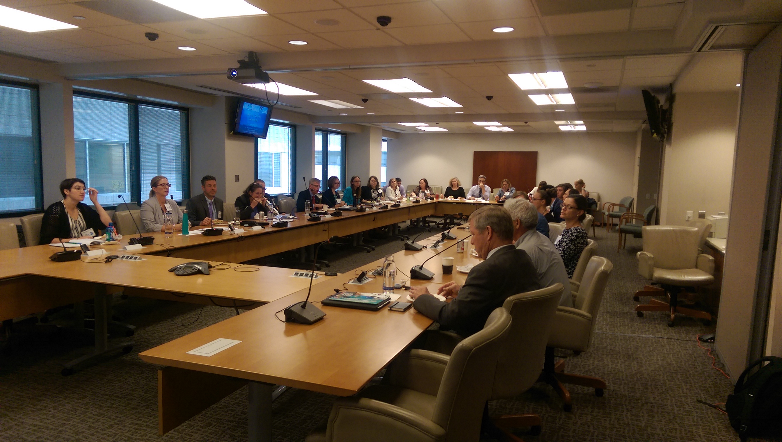 A group of people sitting at a conference room table.