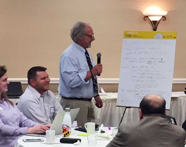 Man teaching class, looking at flip chart