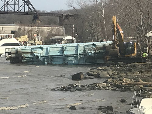 Crane pulling a rail car from a river. 