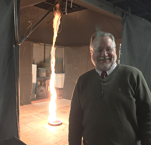 Man with column of fire in the background.