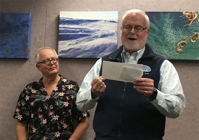 Two men looking at a piece of paper. 