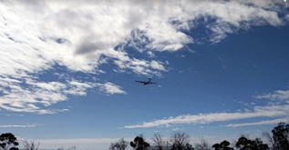 Drone in the air with clouds in background. 