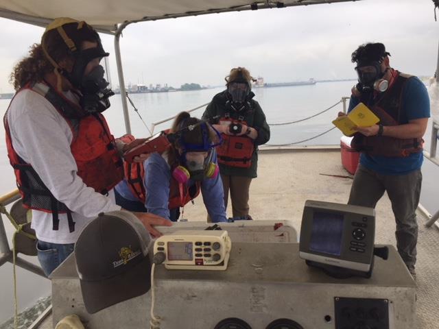 People in pollution masks on a boat.