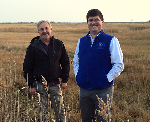 Two men standing in a field.