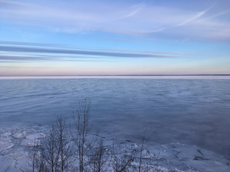Large body of water the is frozen near the shore.