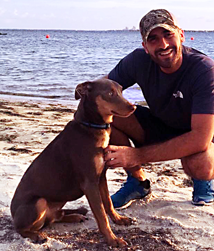 A man and a dog on the beach.