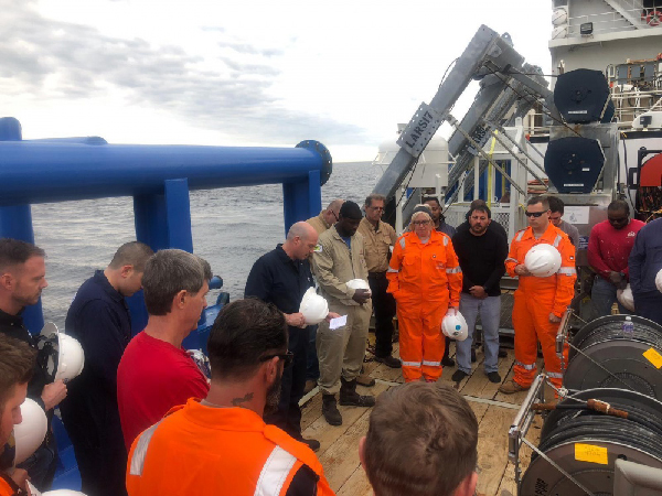 Group of people working on the deck of a boat.