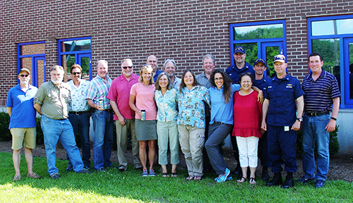 Large group of people pose outdoors for a photo.