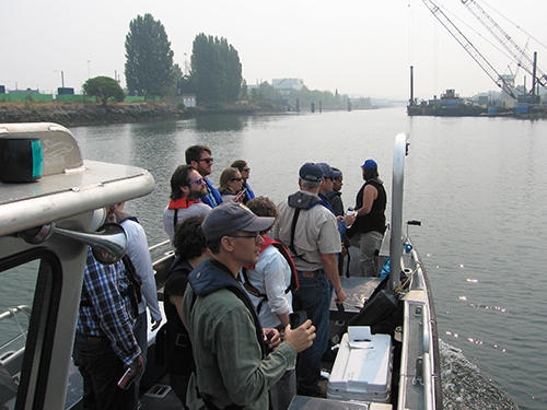 Group of people on a boat deck on a river.