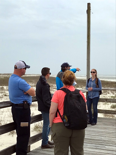 Group of people on a dock looking out towards the water. 