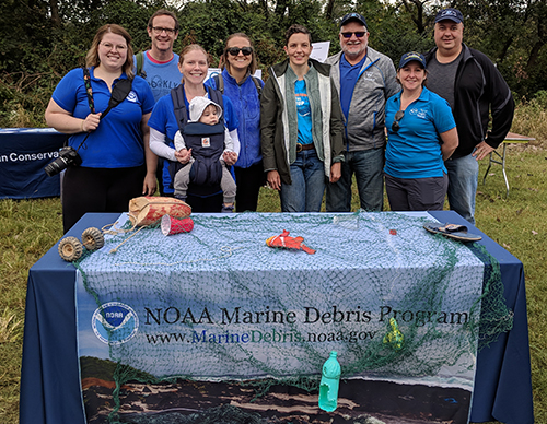 Group of people pose outdoors at a table.