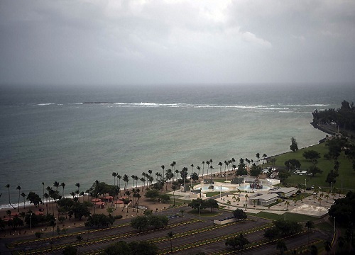 Aerial view of a beach front with dark clouds in the sky.
