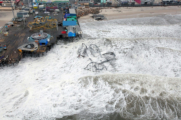 An aerial view of a roller coaster, wrecked, in the ocean.