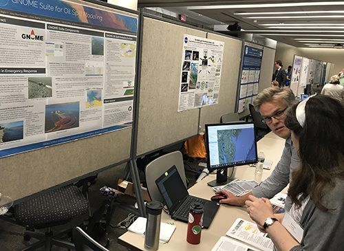 Man explaining something to a woman at a computer. 