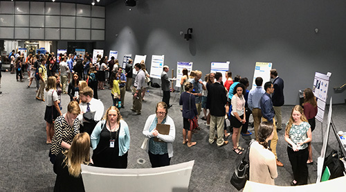 People milling around at a poster session.