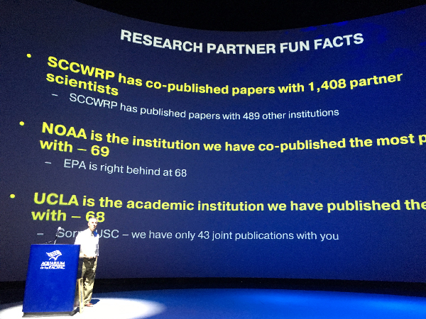 Text projected on a screen, "NOAA is the institution we have co-published the most papers with — 69. 