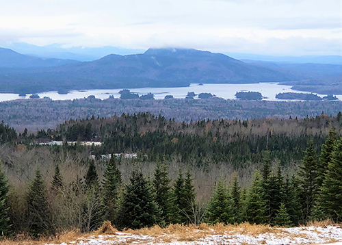 Landscape with lake, hills, and trees. 