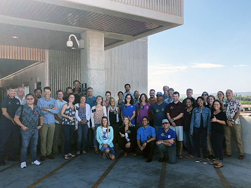 Large group of people posing for a photo outdoors.