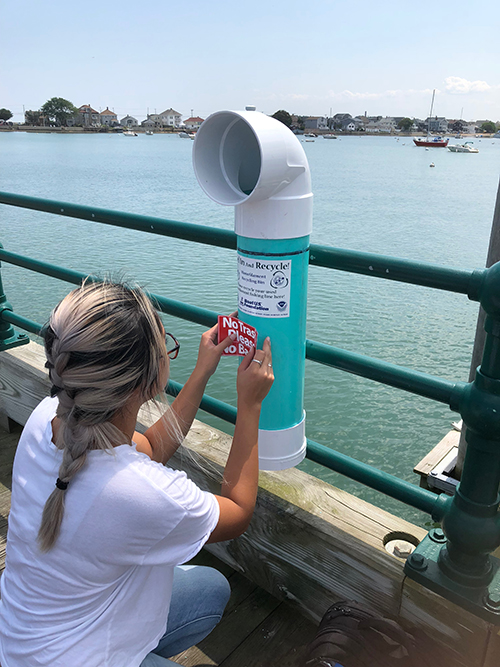 Woman installing a "bin" on a pier.