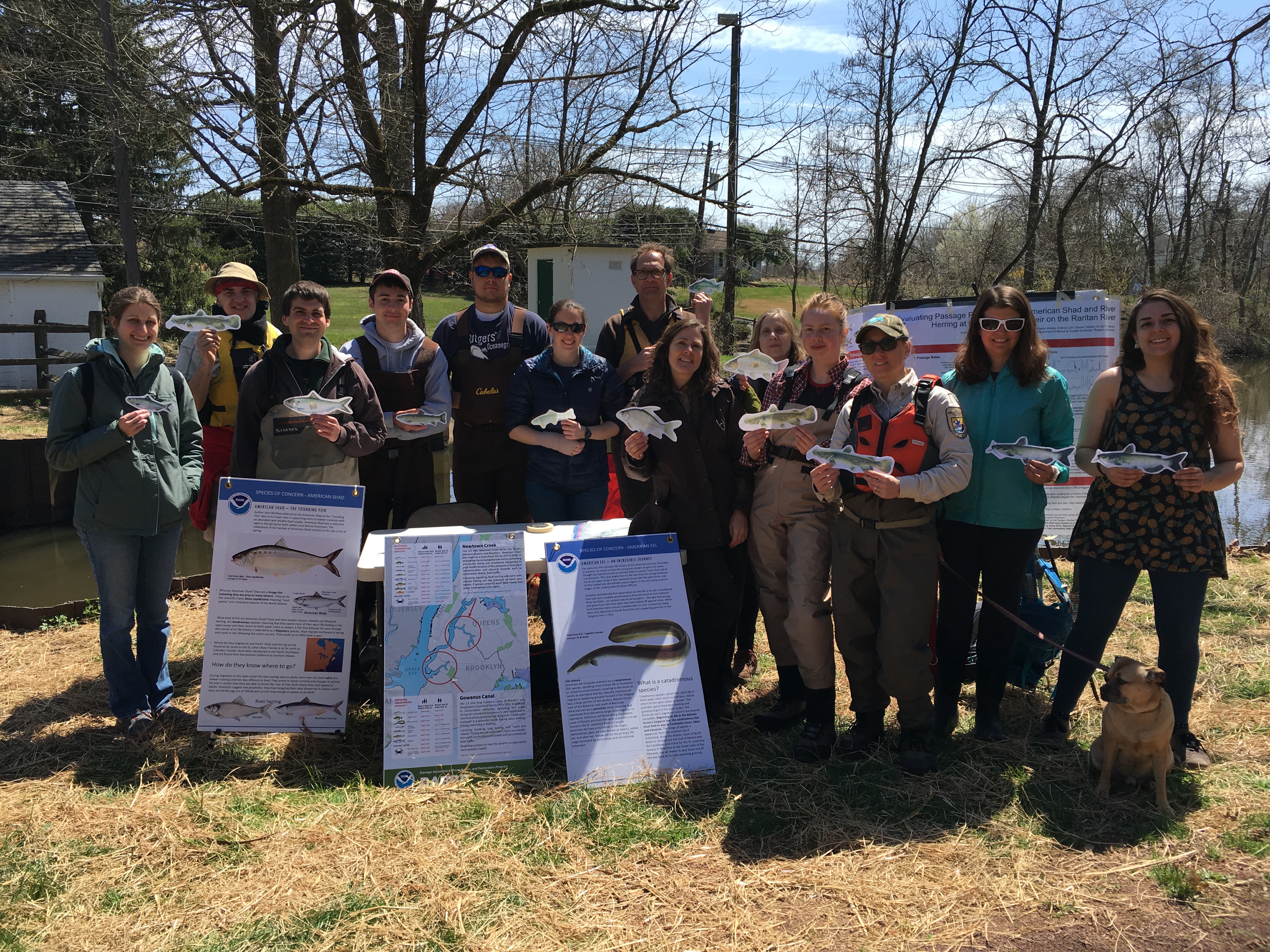 Group of people posing outdoors with posters. 