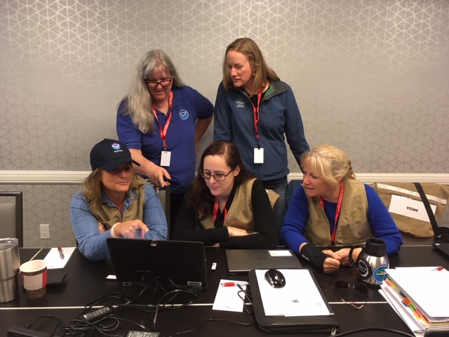 Five people working at a table.