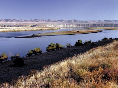 Riverbank, river, and mountains.